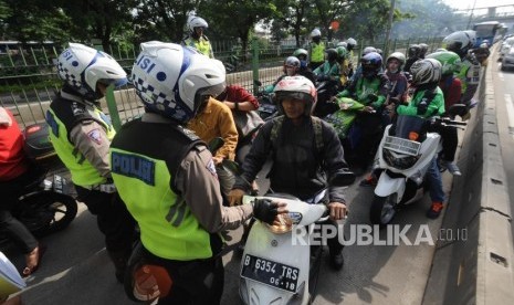 Anggota kepolisian Polda Metro Jaya melakukan penindakan terhadap sejumlah kendaraan roda dua di Jalan Sultan Agung, Jakarta Selatan, Selasa (9/1).