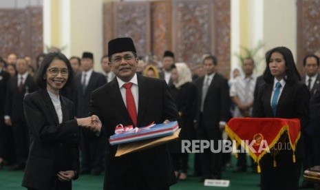 Sekjen DPR RI yang baru Indra Iskandar (kedua kiri) berjabat tangan dengan pejabat lama Plt Sekjen DPR RI Damayanti (kiri) pada acara pelantikan sekjen DPR di Gedung Nusantara IV, Kompleks Parlemen, Senayan, Jakarta, Selasa (22/5).