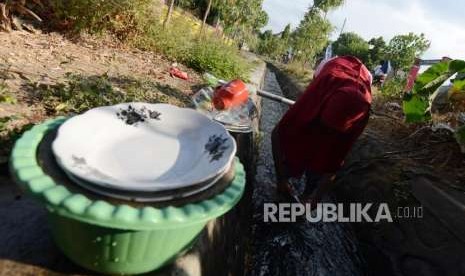 Sejumlah warga mencuci peralatan makan dari aliran saluran air di Sambelia, Lombok Timur, Nusa Tenggara Barat, Selasa (21/8).