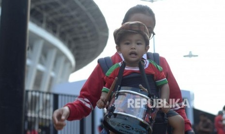 penonton  Piala AFC U19  membawa anak kecil untuk menyaksikan pertandingan sepakbola di   Stadion Utama Gelora Bung Karno, Jakarta, Ahad (28/10).