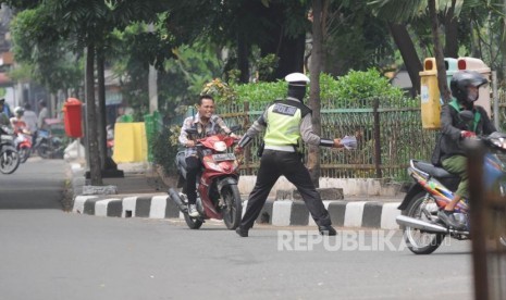 Berusaha Kabur. Pengendara roda dua tidak menggunakan helm mencoba kabur saat akan di berhentikan oleh polisi di  Jalan Letjen Suprapto, Jakarta, Rabu (11/01).