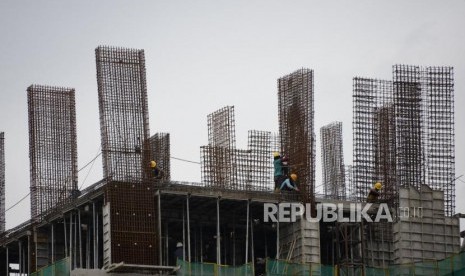 Pertumbuhan Ekonomi. Pekerja beraktivitas pada proyek pembangunan gedung bertingkat di Jakarta, Selasa (12/3).