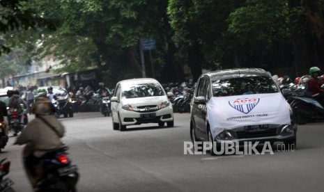 Pengendaran taksi online melintas saat menggelar aksi unjuk rasa di Depan Kantor Grap, Jakarta, Senin (16/4).