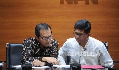 Wakil Ketua KPK Saut Sitomorang (kiri) dan Wakil Ketua KPK Laode M Syarif berbincang saat memberikan keterangan kepada media terkait penetapan tersangka kasus korupsi terhadap calon kepala daerah Maluku Utara, di kantor KPK,  Jakarta, Jumat (16/3).