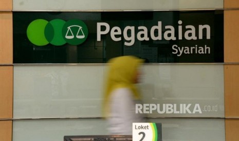 Petugas melayani nasabah ketika bertransaksi di kantor pelayanan Pegadaian Syariah, Jakarta, Jumat (4/1).