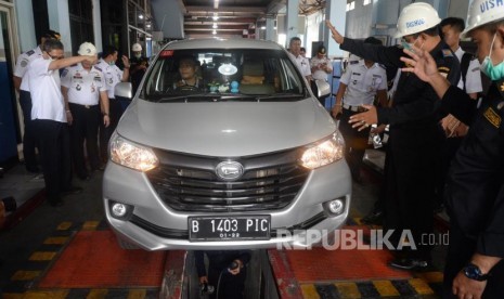 Petugas memeriksa mobil taksi daring saat uji kir di Unit Pengelola Pengujian Kendaraan Bermotor (UP-PKB) Pulogadung, Jakarta.