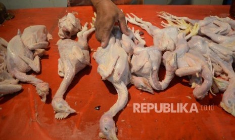 Pedagang melayani pembeli ayam potong di Pasar Jatinegara, Jakarta, Selasa (1/5).