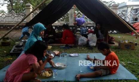 Sejumlah pengungsi korban bencana alam gempa bumi dan tsunami saat makan di Posko Pengungsian Rumah Dinas Gubernur, Palu, Sulawesi Selatan, Rabu (3/10).