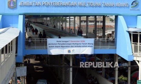 Pejalan kaki melintasi skybridge atau Jembatan Penyeberangan Multiguna (JPM) Tanah Abang, Jakarta, Jumat (7/12).