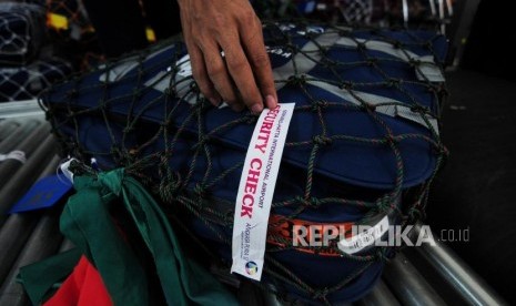 Petugas menempelkan stiker security check kepada koper calon jamaah haji di Asrama Haji Bekasi, Bekasi, Jawa Barat, Ahad (22/7).