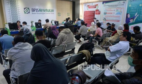 Petugas melayani warga di kantor Badan Penyelanggara Jaminan Sosial (BPJS) Kesehatan KCU Jakarta Pusat, Rabu (1/11).