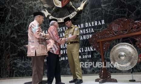 Gubernur DKI Jakarta Anies Baswedan (kanan) berjabatan tangan dengan Ketua MUI Pusat Abdullah Jaidi (kiri) dan Ketua Pengurus MUI DKI Jakarta Syarifuddi Abdul Ghani (tengah) seusai meresmikan pembukaan Musyawarah Daerah Majelis Ulama Indonesia (Musda MUI) Provinsi DKI Jakarta Tahun 2018 di Balaikota, Jakarta, Selasa (9/10).