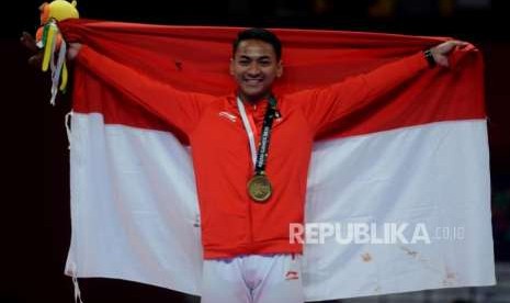 Karateka Indonesia Ahmad Zigi Zaresta Yuda membentangkan bendera merah putih usai pengalungan medali perunggu cabang olahraga karate Asian Games 2018 kategori kata perorangan putra di JCC Plennary Hall, Jakarta, Sabtu (25/8).