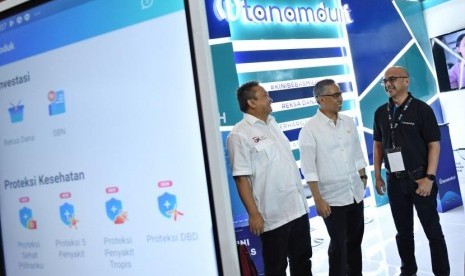 Ketua Dewan Komisioner Otoritas Jasa Keuangan (OJK) Wimboh Santoso (tengah) dan Kepala Eksekutif Pengawas Pasar Modal OJK Hoesen (kiri), berbincang dengan Chief Business Tanamduit M. Hanif saat meninjau stan Tanamduit pada pameran Indonesia Fintech Summit & Expo 2019 di Jakarta Convention Center (JCC), Jakarta, Senin (23/9/2019).