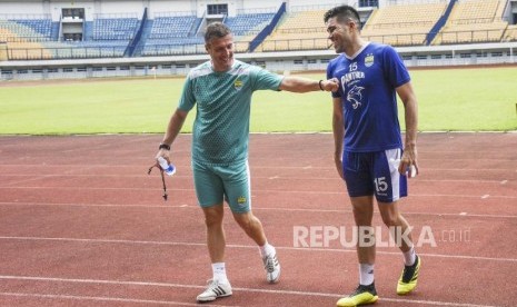 Bek Persib Bandung Fabiano Beltrame (kanan) bercengkerama dengan pelatih Persib Bandung Miljan Radovic (kiri) seusai sesi latihan di Stadion Gelora Bandung Lautan Api, Kota Bandung, Ahad (24/3).