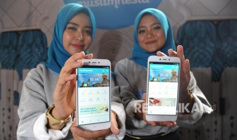 Model memperliatkan aplikasi Muslimnesia saat diperkenalkan di Jakarta, Jumat (3/5).