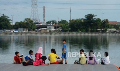 Anak-anak saat bermain di Waduk Cincin, Tanjung Priok, Jakarta Utara, Ahad (13/1).