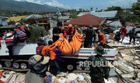 Sejumlah petugas gabungan mengevakuasi jenazah yang tertimbun di Perumnas Balaroa, Palu, Sulawesi Tengah, Senin (1/10).