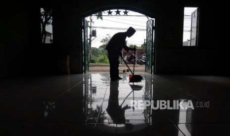 Marbot Musholla Budi Santoso (72) membersihkan Musholla Pemuda, Pancoran Mas, Depok, Jawa Barat, Selasa (27/2).