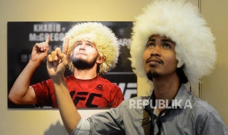 Pameran Foto Islam Rusia. Pengunjung menirukan gaya pada foto atlet bela diri Khabib Nurmagomedov yang dipajang saat pameran foto tradisi umat Islam di Rusia di Musium Bayt Al-Quran TMII, Jakarta, Selasa (26/2).