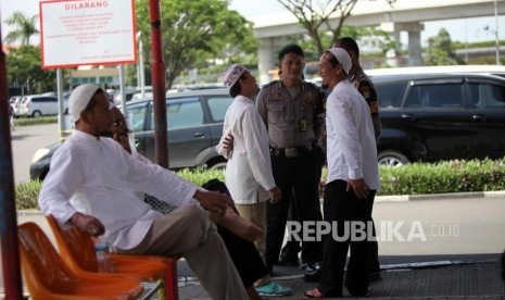 Pendukung Habib Rizieq berbincang dengan petugas polisi saat menunggu kedatangan Habib Rizieq di Bandara Soekarno-Hatta, Tangerang, Banten, Rabu (21/2).