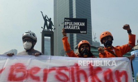 Sejumlah aktivis Gerakan Inisiatif Bersihkan Udara Koalisi Semesta (Ibu Kota) mengendarai sepeda mengggunakan masker saat aksi di Bundaran HI, Jakarta, Rabu (5/12).