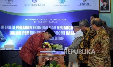 Gubernur Bank Indonesia (BI) Agus Martowardojo bersama Ketua Umum MUI KH. Ma'ruf Amin, Ketua Badan Wakaf Indonesia (BWI) Mohammad Nuh dan Ketua Badan Amil Zakat Nasional (Baznas) Bambang Sudibyo (dari kiri) saat penandatanganan nota kesepahaman di Kantor MUI, Jakarta, Rabu (24/1).