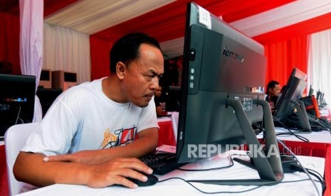 Warga melakukan ujian teori pada kegiatan pembuatan SIM A Umum kolektif untuk pengemudi angkutan taksi online dan konvensional di kawasan Gelora Bung Karno (GBK), Senayan, Jakarta, Ahad (25/2).