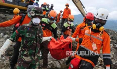 Relawan ACT bersama TNI dan tim evakuasi bencana lainnya mengangkat jenazah yang baru ditemukan di perumnas Balaroa, Palu, Sulawesi Tengah, Kamis (11/10).