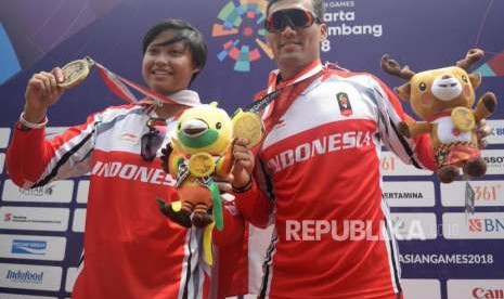 Atlet Sepeda BMX Putra Indoensia I Gusti Bagus Saputra (kanan) dan Atlet Sepeda BMX Putri Indoensia Wiji Lestari menunjukan medali usai pertandingan final cabang sepeda BMX putra dan putri Asian Games 2018 di Pulomas Internasional BMX Center, Jakarta, Sabtu (25/8).