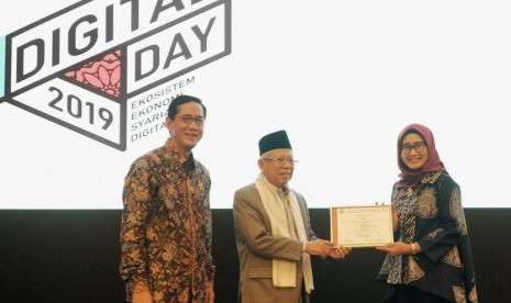 Direktur Utama Telkomsel Emma Sri Martini (kanan) menerima sertifikat dari Ketua Umum MUI KH Ma ruf Amin (tengah) yang didampingi Direktur Eksekutif KNKS Ventje Rahardjo pada Islamic Digital Day 2019, di Jakarta, Senin (16/9/2019).