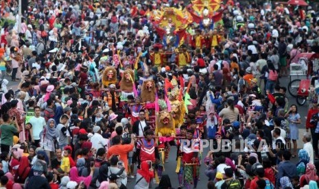 Peserta Jakarnaval 2018 melintas di Jalan Medan Merdeka Barat, Jakarta, Ahad (8/7).