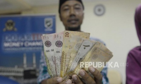 Calon jamaah haji memperlihatkan mata uang Saudi Riyal di Asrama Haji Pondok Gede, Jakarta, Rabu (17/7).