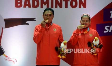 Pebulu tangkis Indonesia Leani Ratri Oktila dan Hary Susanto menggigit medali emas usai melawan pebulu tangkis Thailand Siripong Teamarrom dan Nipada Saensupa dalam babak final bulu tangkis nomor ganda campuran SL3-SU5 Asian Para Games 2018 di Istora Senayan, Jakarta, Sabtu (13/10).