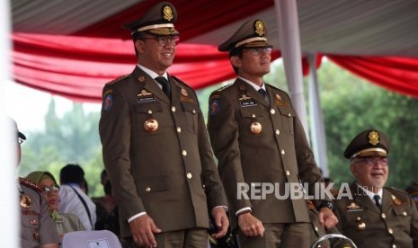 Gubernur DKI Jakarta Anies Baswedan bersama Wakil Gubernur DKI Jakarta Sandiaga Uno menghadiri Apel besar dalam rangka memperingati HUT Satpol PP ke-68 di Lapangan Monas, Jakarta, Kamis (26/4).