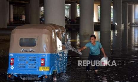 Supir bajaj mencuci kendaraannya memanfaatkan genangan air di Terowongan Apron, Jalan HBR Motik, Kemayoran, Jakarta, Selasa (11/9).