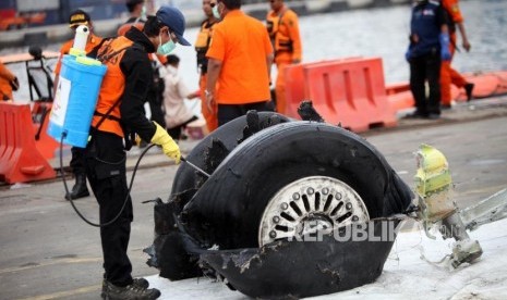 Petugas menyemprotkan disinfektan ke puing-puing pesawat Lion Air JT-610 di Tanjung Priok, Jakarta, Senin (5/11).