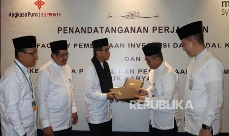 Direktur Wholesale Banking Mandiri Syariah Kusman Yandi (kedua kanan) bersama Direktur Utama PT Angkasa Pura Support Iwan Hartawan (ketiga kiri) saling bertukar notakesepakatan bersama yang sudah ditandatangani mengenai Perjanjian Line Facility Pembiayaan Investasi dan Modal Kerja dengan limit total sebesar Rp600 Miliar, disaksikan oleh Direktur Utama Mandiri Syariah Toni EB Subari (kanan), Direktur Komersial dan Teknik Mandiri Syariah Trikora Harjo dan Direktur SDM Keuangan dan Umum Mandiri Syariah Sugiarto Panca Karyaningadi di Jakarta, Jumat (17/5).