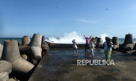 Waspada Ombak Besar Pantai Selatan. Wisatawan berfoto dengan deburan ombak di Pantai Glagah, Kulonprogo, Yogyakarta, Rabu (12/6/2019).