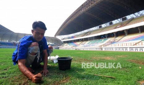 Pekerja melakukan perawatan rumput Stadion Wibawa Mukti, Cikarang, Bekasi, Jawa Barat, Jumat (13/7).