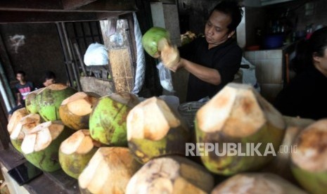 Pedagang es kelapa muda. Air kelapa dapat membantu mengisi elektrolit yang hilang setelah sesi olahraga yang berkeringat.