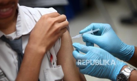 Seorang siswa melakukan imunisasi difteri saat sosialisasi komitmen pelaksaan kegiatan Outbreak Response Immunization (ORI) Difteri di Sekolah SMAN 33 Jakarta, Jalan Kamal Raya, Jakarta Barat, Senin (11/12).