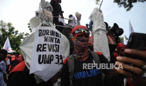 Seorang buruh berswa foto dalam aksi demo di depan Balaikota DKI Jakarta, Jumat(10/11). Aksi unjuk rasa ini bertujuan menolak upah murah dan meminta Gubernur DKI Jakarta Anies Baswedan untuk merevisi UMP DKI Jakarta.