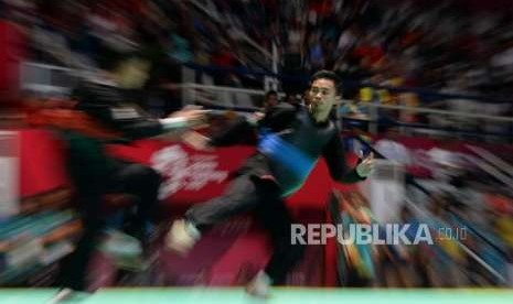 Pesilat Indonesia Abdul Malik (pita biru) bertanding melawan pesilat Malaysia Muhammad Faizul M Nasir pada babak final cabang pencak silat putra kelas B 50-55 kg Asian Games 2018 di Padepokan Pencak Silat, TMII, Jakarta, Senin (27/8).