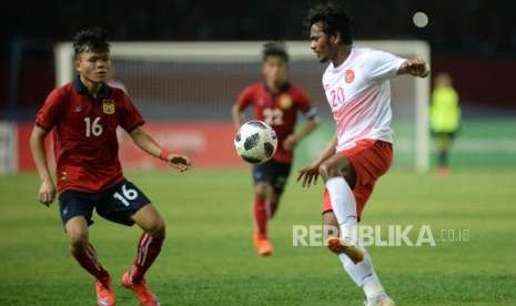 Pesepak bola Indonesia  Ilham Udin Afmaiyn berusaha melewati pemain Laos pada laga penyisihan Grup A cabang sepak bola Asian Games 2018 di Stadion Patriot, Bekasi, Jumat(17/8).