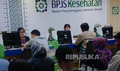 Petugas melayani warga di kantor Badan Penyelanggara Jaminan Sosial (BPJS) Kesehatan KCU Jakarta Pusat, Rabu (1/11).