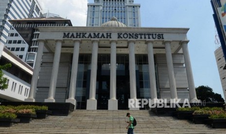 Pengunjung melintas di depan Gedung Mahkamah Konstitusi, Jakarta, Kamis (23/5).