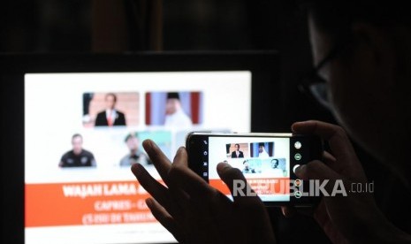 Seorang jurnalis memotret persentasi  terkait hasil survei menjelang Pilpres 2019. Ilustrasi