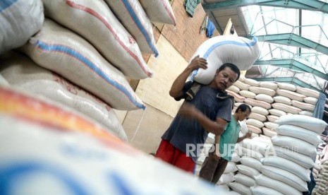 Pekerja memindahkan beras di Pasar Induk Beras Cipinang, Jakarta.