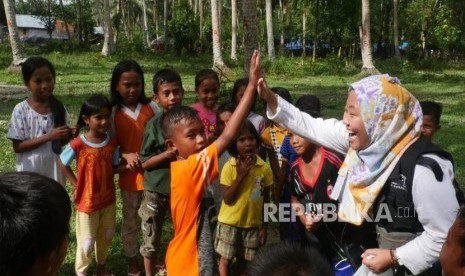 Seorang relawan ACT bermain dengan anak-anak di desa Lompio Kabupaten Sirenja, Donggala Sulawesi Tengah, Ahad (14/10).